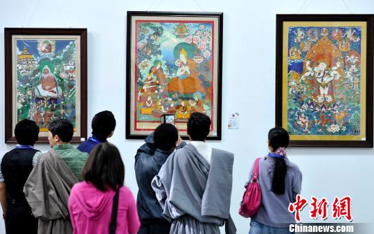 8月13日，观众正在欣赏展出的唐卡作品。　李林 摄