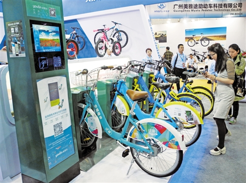 在第27届中国国际自行车展览会上，观众正在对着一款已经实现有桩公共自行车与无桩共享单车互联互通的单车扫码。经济日报记者 孟 飞摄